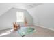 room with an angled ceiling, rocking chair, giraffe toy, play mat, and a window at 436 Westlake Nw Dr, Marietta, GA 30064