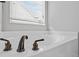 Close up of a soaking tub with bronze hardware at 1205 Campbell Ridge Ln, Lawrenceville, GA 30045