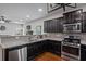 Charming kitchen with dark wood cabinetry, granite counters, stainless steel appliances, and gas range at 1205 Campbell Ridge Ln, Lawrenceville, GA 30045