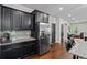 Kitchen featuring dark cabinetry, granite counters, tile backsplash, and stainless steel appliances at 1205 Campbell Ridge Ln, Lawrenceville, GA 30045