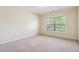 Empty bedroom with neutral walls and carpet, plus a window for natural light at 1520 Ethans Way, Mcdonough, GA 30252
