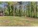 Spacious backyard surrounded by lush green trees and grass at 204 Holly Creek Way, Woodstock, GA 30188