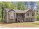 Exterior of the home featuring stone accents, wood siding, and front porch at 204 Holly Creek Way, Woodstock, GA 30188