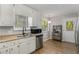 Bright kitchen with white cabinets, stainless steel appliances, and laminate floors at 204 Holly Creek Way, Woodstock, GA 30188