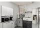 Cozy kitchenette area featuring modern appliances, cabinets, sink and stylish backsplash at 204 Holly Creek Way, Woodstock, GA 30188