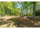 Expansive backyard with mature trees and a wood fence, perfect for outdoor activities at 2264 Howell Farms Nw Trl, Acworth, GA 30101