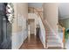 Bright foyer with hardwood floors, staircase with white railings, and a view of the upper level landing at 2264 Howell Farms Nw Trl, Acworth, GA 30101
