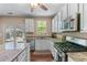 Well-lit kitchen boasts white cabinetry, granite counters, stainless steel appliances and a view to the backyard at 2264 Howell Farms Nw Trl, Acworth, GA 30101