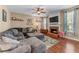 Comfortable living room featuring a fireplace, large sectional sofa, hardwood floors, and abundant natural light at 2264 Howell Farms Nw Trl, Acworth, GA 30101