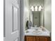 Stylish powder room with a wood vanity, large mirror, pendant lights, and neutral paint at 2264 Howell Farms Nw Trl, Acworth, GA 30101