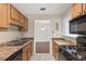 Well-lit kitchen featuring granite counters, wood cabinetry, and access to the dining area at 2308 Country Park Se Dr, Smyrna, GA 30080