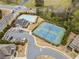 This aerial showcases the community tennis courts, pool, clubhouse, and parking at 441 Spring View Dr, Woodstock, GA 30188