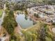 Aerial view of the neighborhood pond with surrounding homes, trees, and landscaping at 441 Spring View Dr, Woodstock, GA 30188