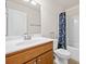 Well-lit bathroom features a white sink, wood cabinets, a large mirror, and a bathtub with a stylish blue floral curtain at 441 Spring View Dr, Woodstock, GA 30188