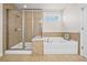Bright bathroom featuring a glass enclosed shower, a soaking tub, and tile accents at 441 Spring View Dr, Woodstock, GA 30188
