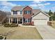 Charming two-story home featuring a red brick facade, manicured landscaping, and an attached two-car garage at 441 Spring View Dr, Woodstock, GA 30188