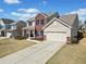 Attractive two-story home showcasing a well-maintained lawn, brick accents, a front porch, and an attached garage at 441 Spring View Dr, Woodstock, GA 30188