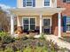 Cozy front porch featuring outdoor seating and decorative plants, complemented by brick accents and a well-maintained garden at 441 Spring View Dr, Woodstock, GA 30188