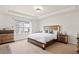 Spacious main bedroom with a tray ceiling includes a large window, and matching wood furniture at 441 Spring View Dr, Woodstock, GA 30188