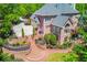 Expansive brick backyard featuring a landscaped terrace, manicured shrubs and lawn, and a multilevel deck at 2644 Nutwood Trce, Duluth, GA 30097