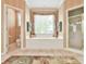 This bathroom features a tub with a window, a walk-in shower, a toilet, and neutral wallpaper at 2644 Nutwood Trce, Duluth, GA 30097