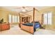 Spacious bedroom with a four-poster bed, built-in shelving, and natural light from shuttered windows at 2644 Nutwood Trce, Duluth, GA 30097