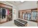 This walk-in closet features custom storage, a leather ottoman, and carpeted floors at 2644 Nutwood Trce, Duluth, GA 30097