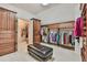 This walk-in closet features custom storage, a leather ottoman, and carpeted floors at 2644 Nutwood Trce, Duluth, GA 30097