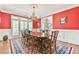 Elegant dining room with red walls, beautiful chandelier, and hardwood floors at 2644 Nutwood Trce, Duluth, GA 30097