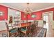 Classic dining room with red walls, wood floors, a decorative chandelier, and seating for eight at 2644 Nutwood Trce, Duluth, GA 30097
