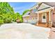 Brick home with a spacious driveway and a three-car garage, next to a front door with steps at 2644 Nutwood Trce, Duluth, GA 30097