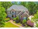 Beautiful brick home featuring mature landscaping, a manicured lawn, and a brick walkway to the front door at 2644 Nutwood Trce, Duluth, GA 30097