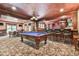 Spacious game room features a billiard table, bar with seating, and custom wood accents throughout at 2644 Nutwood Trce, Duluth, GA 30097