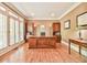 Home office featuring hardwood floors, wood desk and shelving, and large shuttered windows at 2644 Nutwood Trce, Duluth, GA 30097