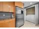 Kitchenette featuring wooden cabinetry, stainless steel refrigerator and washer/dryer closet at 3338 Peachtree Ne Rd # 1010, Atlanta, GA 30326