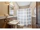 Cozy bathroom with a pedestal sink, tiled floors, striped shower curtain, and classic fixtures at 698 Bellemeade Nw Ave, Atlanta, GA 30318