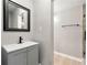 Well-lit bathroom featuring a gray vanity, black fixtures, and a framed mirror at 7260 Foxberry Ct, Cumming, GA 30041