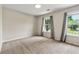 Cozy bedroom with neutral tones, plush carpeting, and large windows, offering a tranquil retreat for rest and relaxation at 7260 Foxberry Ct, Cumming, GA 30041