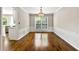 Formal dining room with hardwood floors, wainscoting, chandelier, and a large window with backyard view at 7260 Foxberry Ct, Cumming, GA 30041
