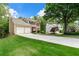 Spacious home featuring a long driveway, a two-car garage, and a beautifully landscaped front yard at 7260 Foxberry Ct, Cumming, GA 30041