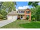 Charming two-story home with a manicured lawn, two-car garage, and traditional architectural details at 7260 Foxberry Ct, Cumming, GA 30041