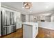Modern kitchen with stainless steel appliances, white cabinets, a center island, and hardwood floors at 7260 Foxberry Ct, Cumming, GA 30041