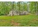 Large backyard with lush lawn and mature trees, showcasing the home's exterior with deck and windows at 151 Mark Se Ln, Smyrna, GA 30082