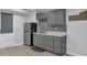 Basement kitchenette featuring gray cabinets, tile backsplash, stainless steel refrigerator, and modern design at 151 Mark Se Ln, Smyrna, GA 30082