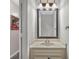 Powder bathroom with a single sink vanity, framed mirror, and neutral walls at 151 Mark Se Ln, Smyrna, GA 30082