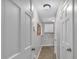 Hallway featuring neutral walls, white doors, overhead lighting, and utility room at the end of the hallway at 151 Mark Se Ln, Smyrna, GA 30082