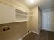Functional laundry room area with storage shelves and convenient access to an exterior door at 16 Grandview Ct, Powder Springs, GA 30127