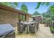 View of the outdoor dining on the back deck with a brick exterior and access to the house at 2687 Goodfellows Rd, Tucker, GA 30084