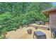 A view of the back deck with table and chairs, surrounded by a heavily wooded lot at 2687 Goodfellows Rd, Tucker, GA 30084