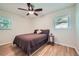 Relaxing bedroom featuring hardwood floors, two windows with natural light, and ceiling fan at 2687 Goodfellows Rd, Tucker, GA 30084